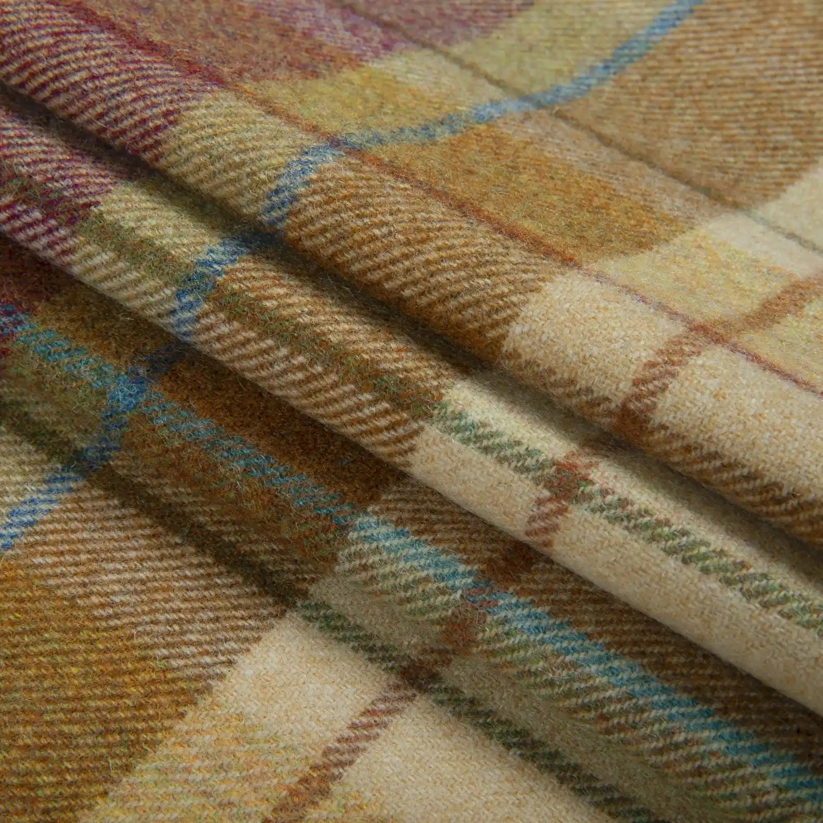 Draped woolly plaid fabric in earthy brown and yellow tones featuring striking teal blue and subtle maroon lines