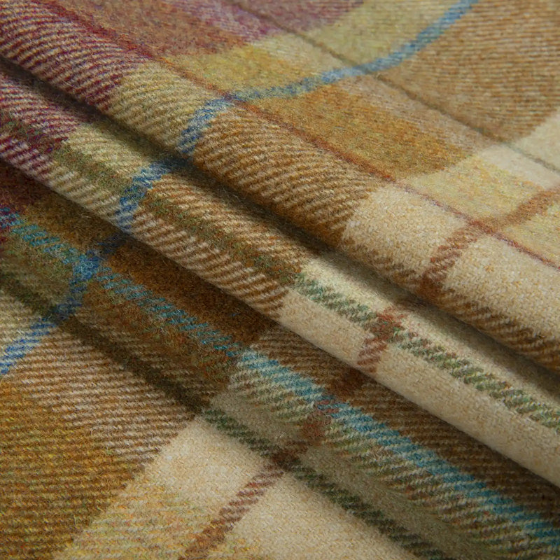 Draped woolly plaid fabric in earthy brown and yellow tones featuring striking teal blue and subtle maroon lines